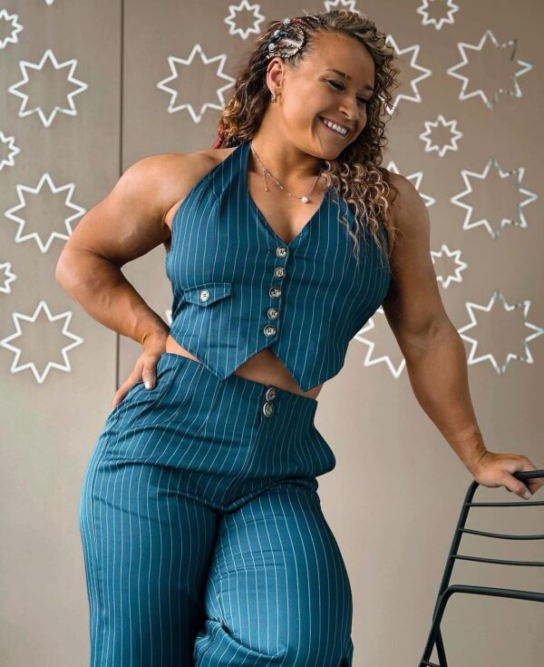 Jordynne Grace wearing a teal pinstripe outfit consisting of a halter top and high-waisted pants. 